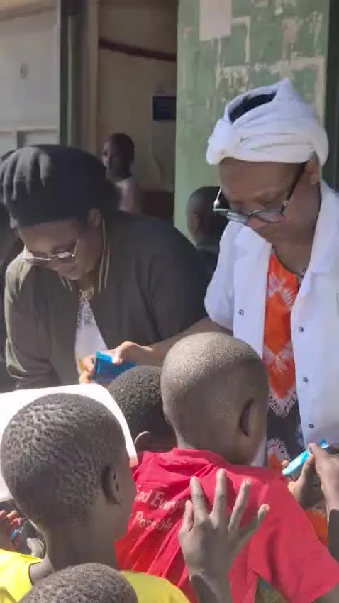 Des adultes réunis auprès des enfants lors d’une distribution.